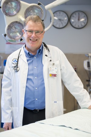 Dr. Ian Stiell stands beside an emergency department bed